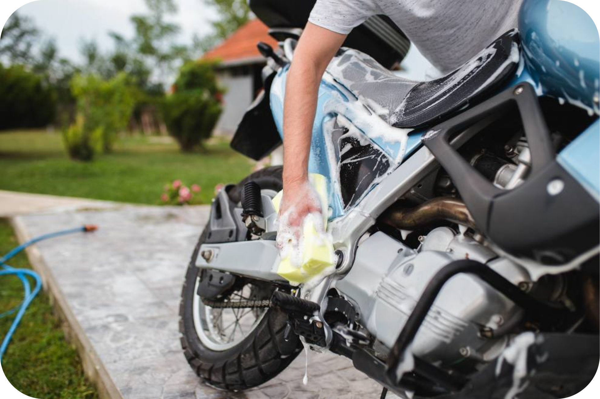 Persona limpiando la moto con esponja y jabón